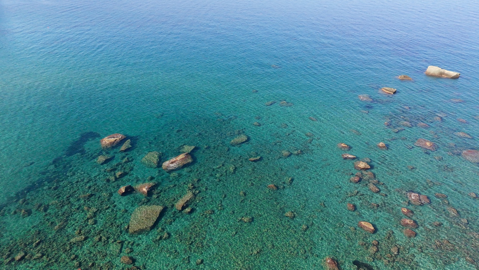 The crystal-clear waters of Citara Beach on Ischia's western coast. Thanks to the island's volcanic seabed and exceptional water clarity, the sea often takes on stunning shades of emerald green and turquoise.